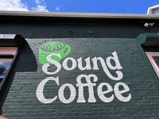 Sound Coffee mural on brick wall with green coffee cup logo, Bridgeport CT coffee shop