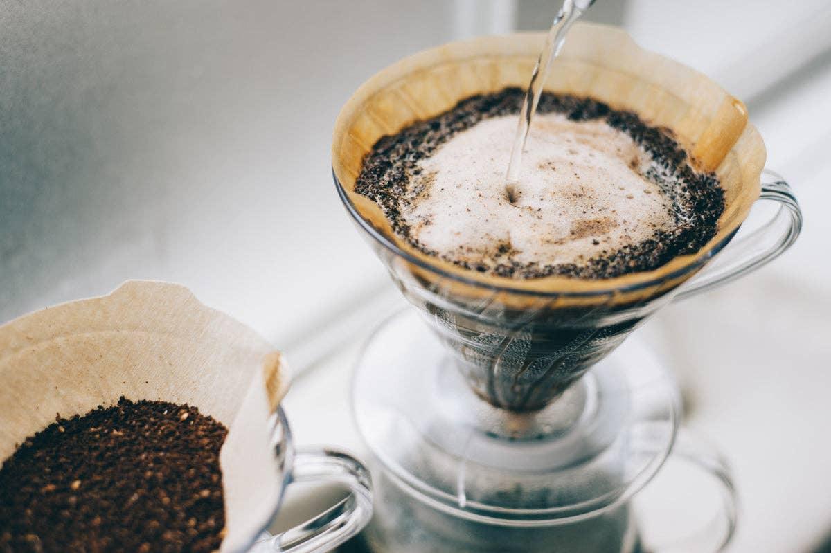 Freshly brewed pour-over coffee with ground beans in a glass dripper at Sound Coffee
