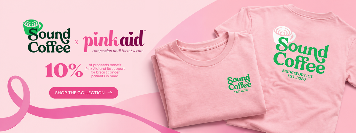 A banner that says Sound Coffee x Pink Aid and the 10% of the proceeds benefit the Pink Aid in support of breast cancer patients, and a folded and open tee on the side with the Sound Coffee logo on it