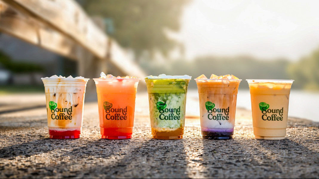 Five colorful coffee drinks from Sound Coffee on a stone surface with a blurred natural background